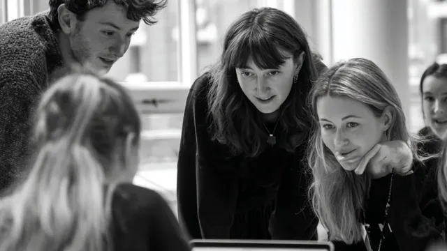 A small group working together around a laptop.